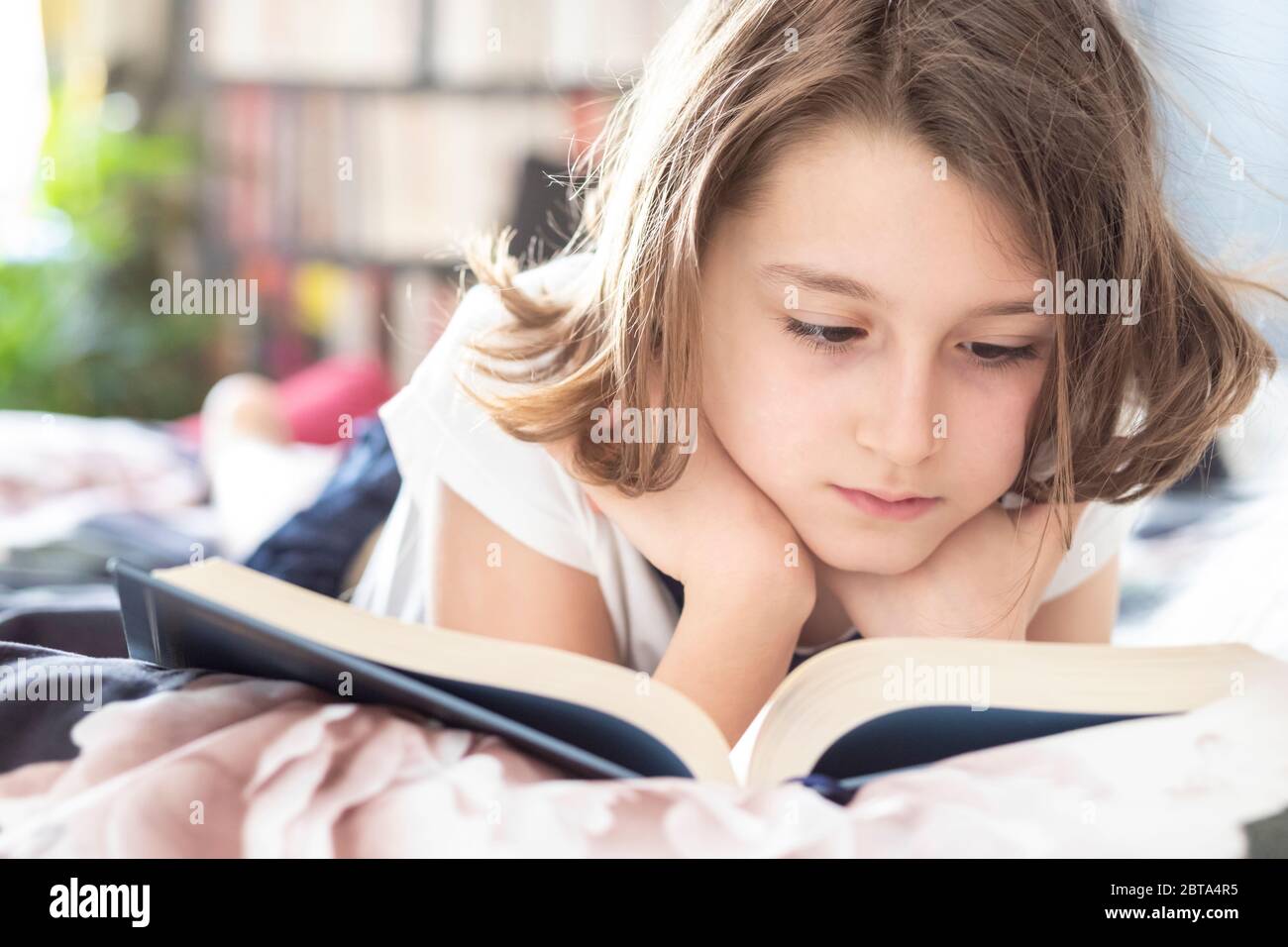 Girl lying bed reading book hires stock photography and images Alamy