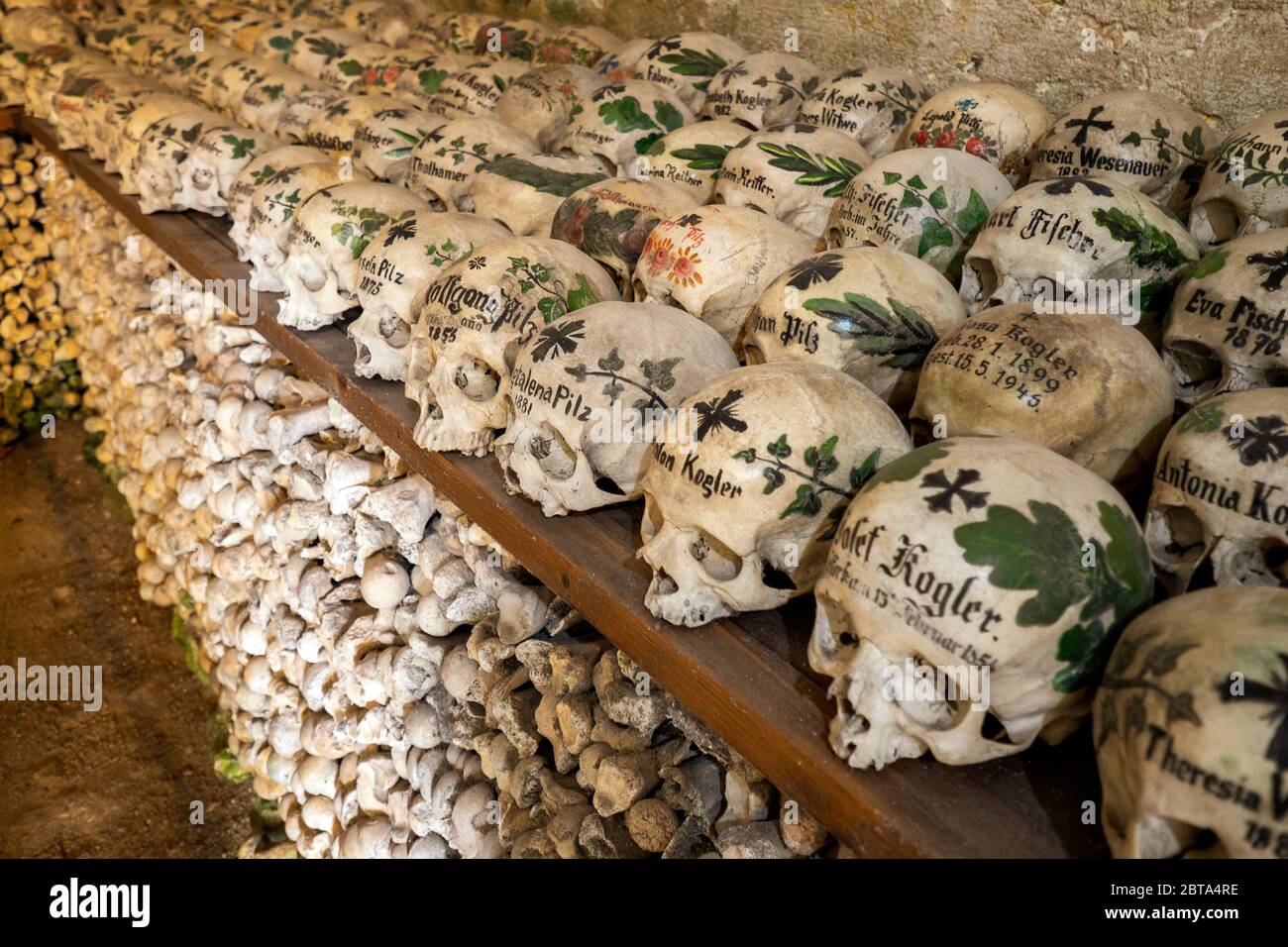 View of hundreds of painted skulls and bones inside the famous charnel house at the mountain village Hallstatt in the Salzkammergut region, Austria Stock Photo