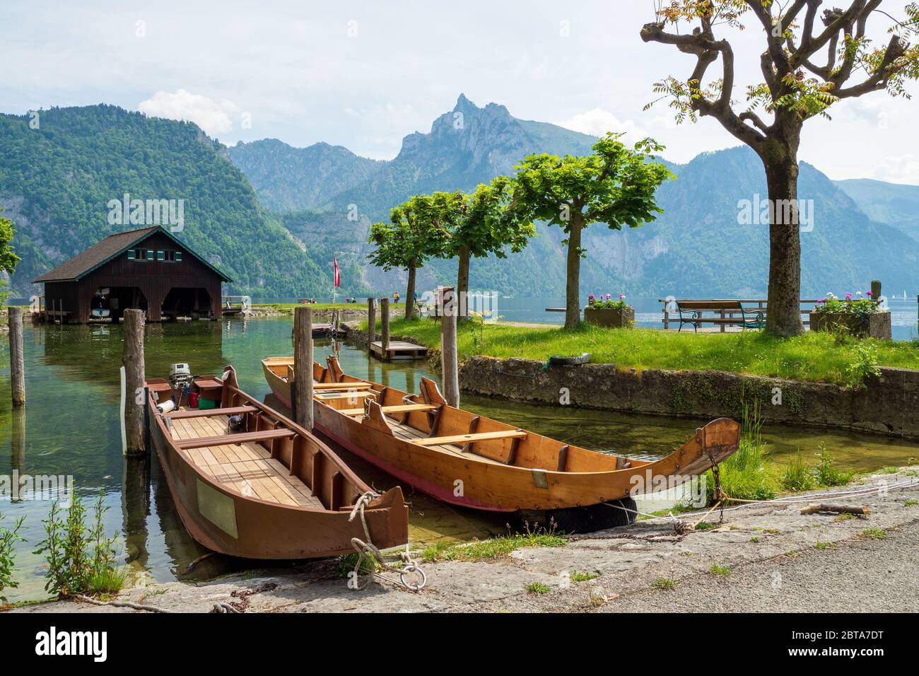View of two "Plätten", traditional wooden flat-bottomed boats, sitting on the lakeshore of the Traunsee at Traunkirchen, Salzkammergut region, Austria Stock Photo