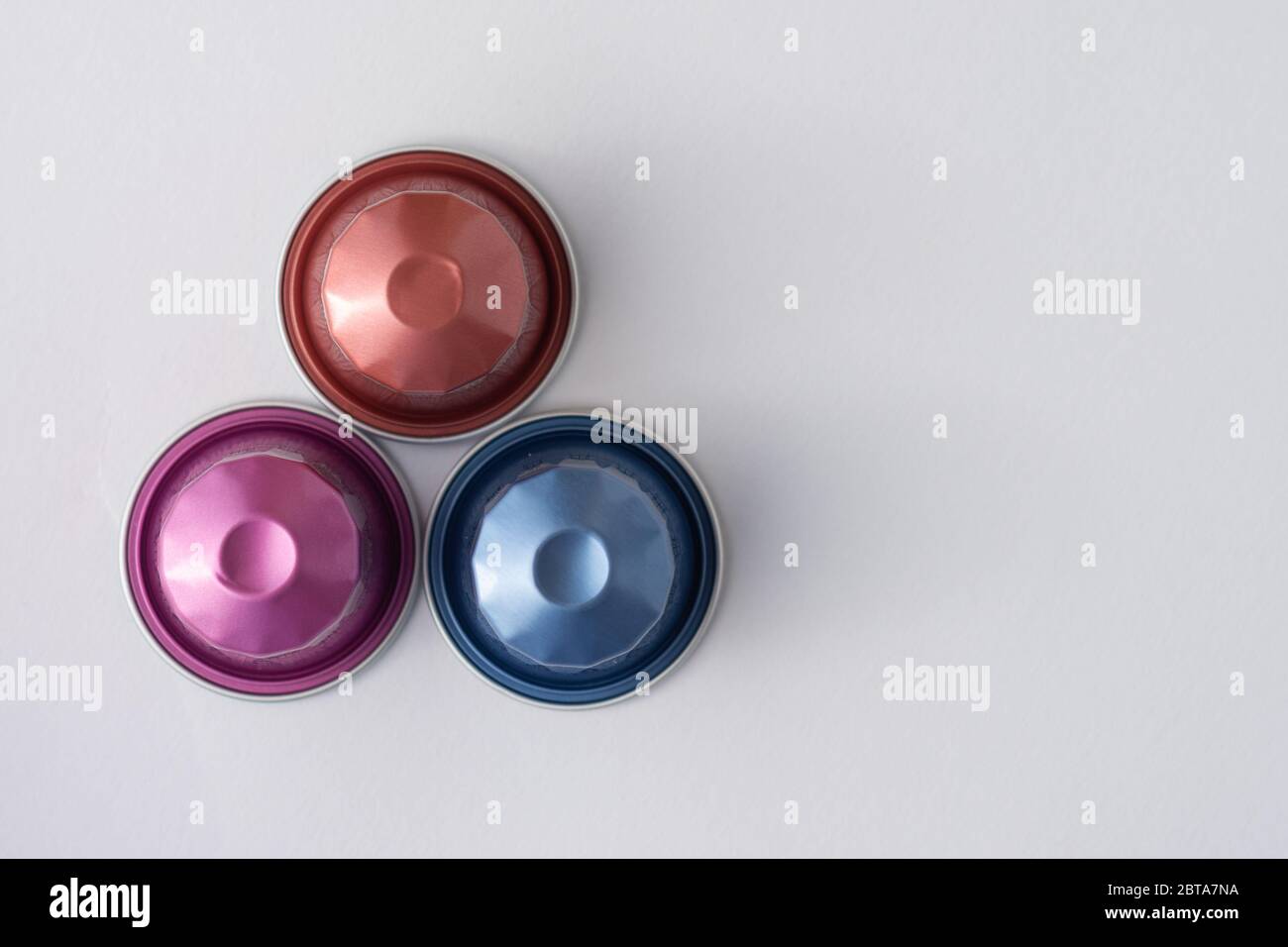 Coffee Capsules in varying colours on a white background viewed from the top. Stock Photo