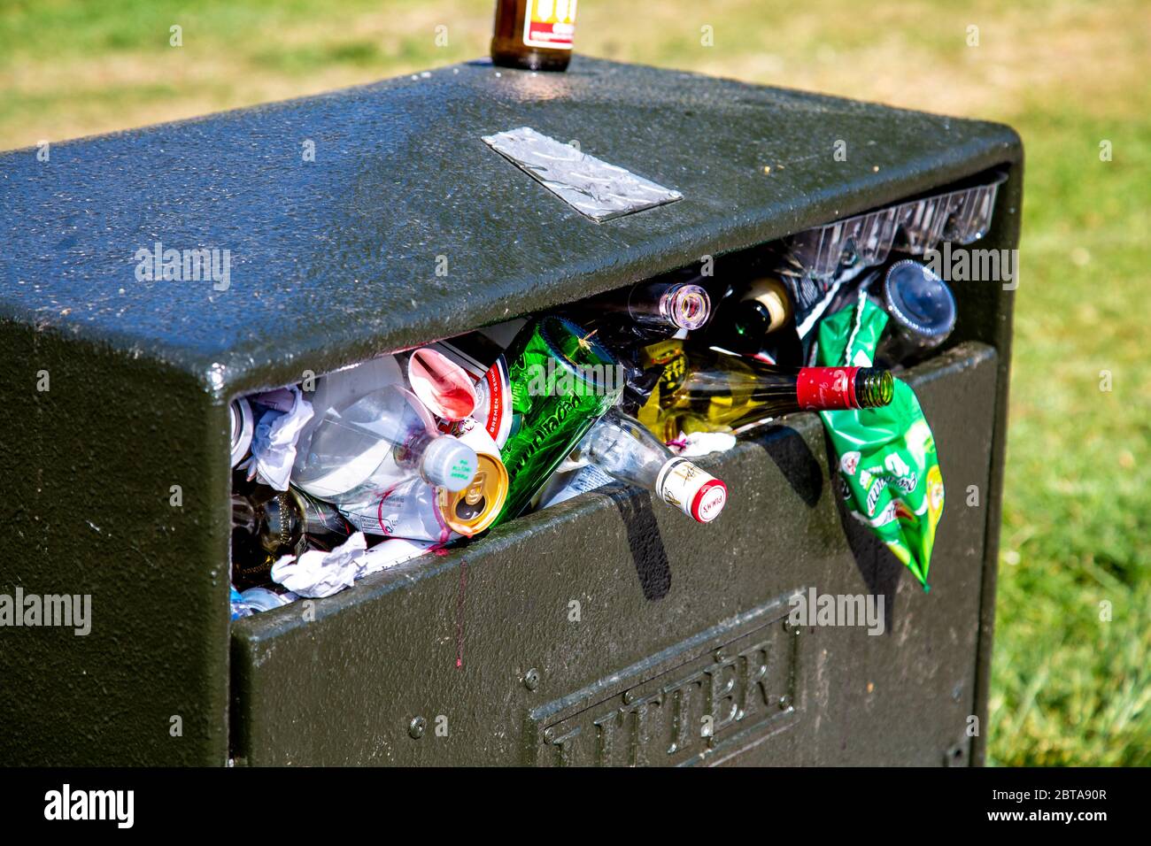 A litter bin in a park overflowing and full of rubbish (Battersea Park, London, UK) Stock Photo