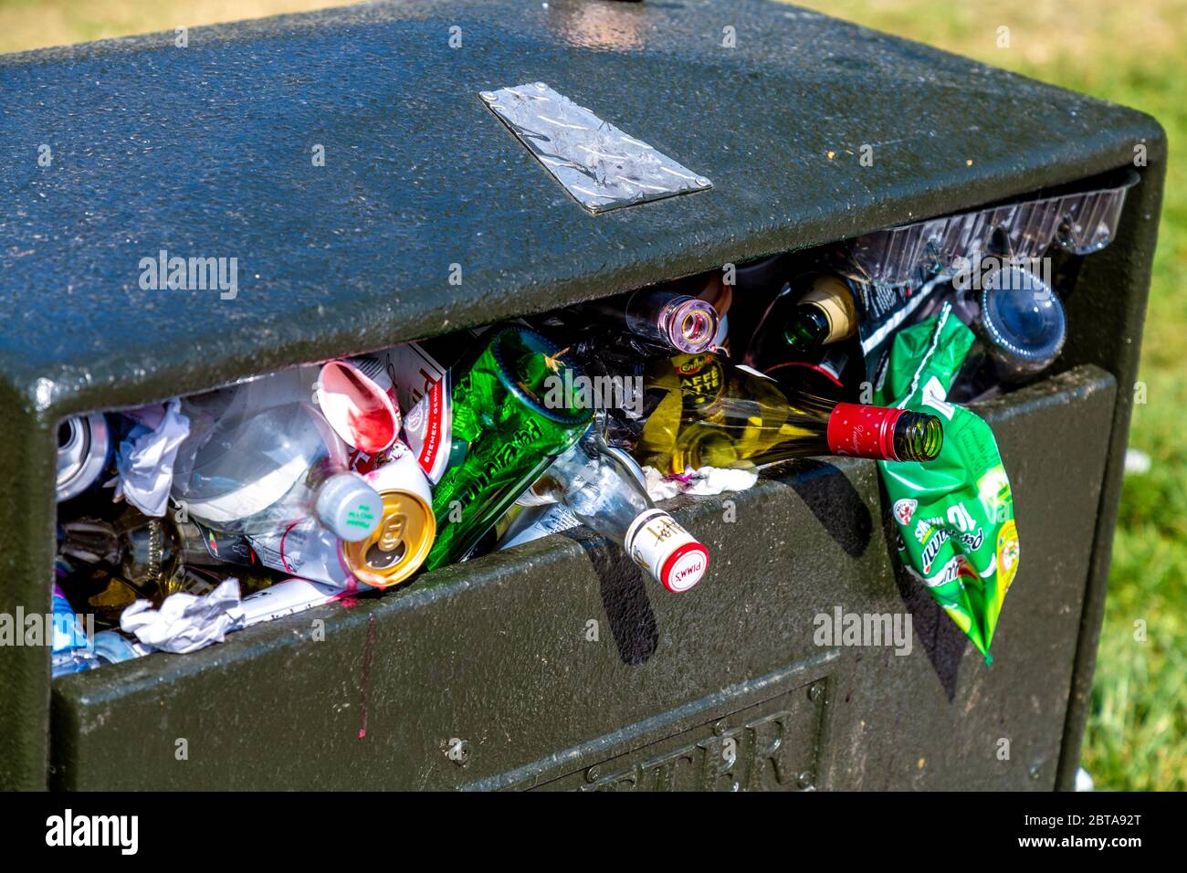 A litter bin in a park overflowing and full of rubbish (Battersea Park, London, UK) Stock Photo