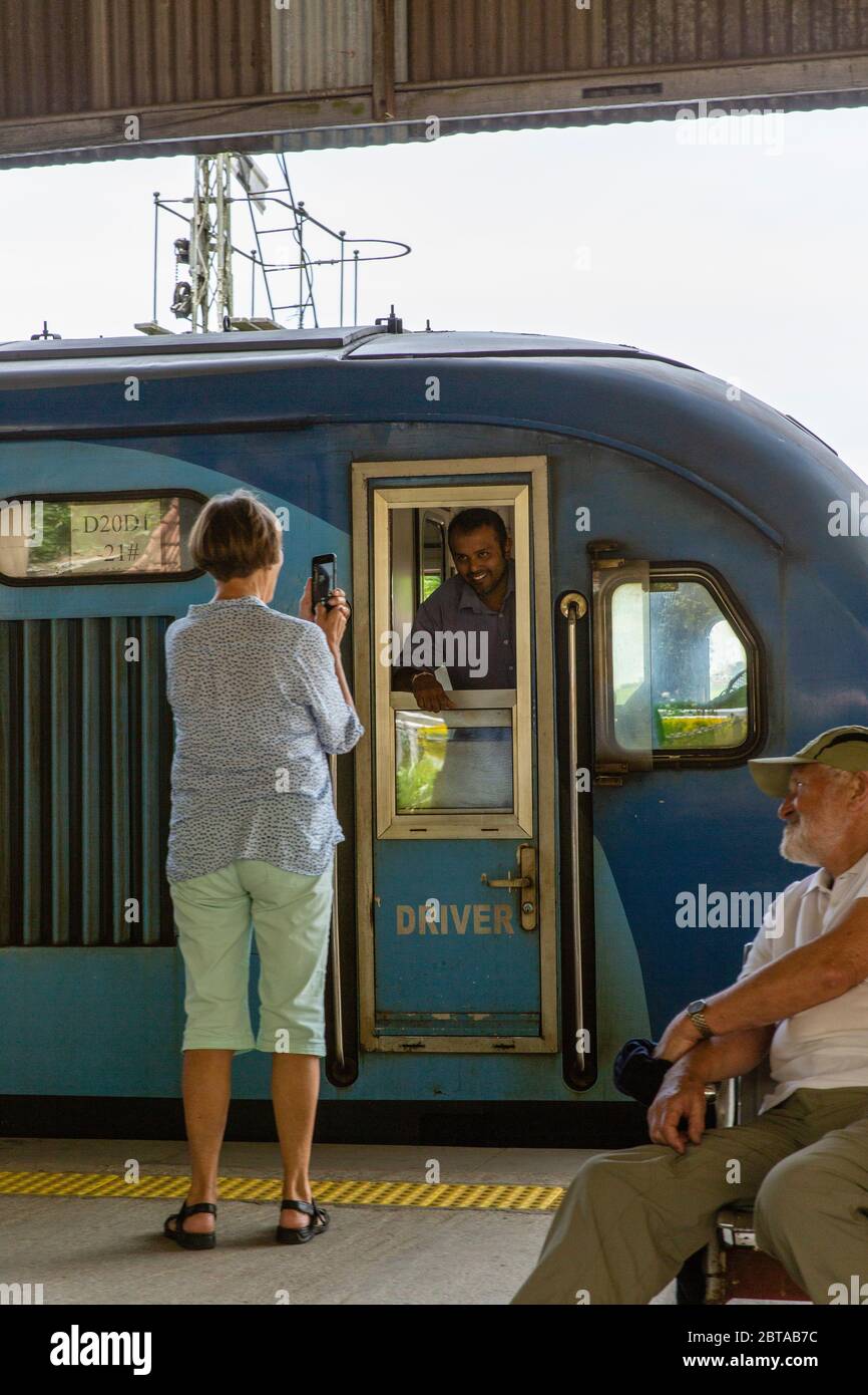 Train to Ella from Nanu Oya.  A tourist takes a picture of a train driver stopped at the station. Stock Photo