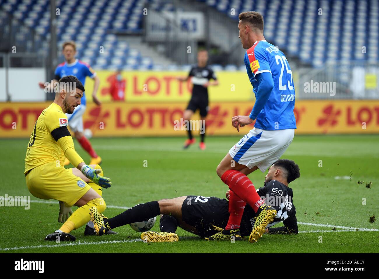 Kiel, Germany. 24th May, 2020. Football: 2nd Bundesliga, Holstein Kiel - VfB Stuttgart, 27th matchday at the Holstein Stadium. Ioannis Gelios (l), goalkeeper of Holstein Kiel, fends off a ball from Nicolas Gonzalez (below) of VfB Stuttgart, while Kiele watch Phil Neumann. Credit: Stuart Franklin/Getty Images Europe/Pool/dpa - only for use in accordance with contractual agreement/dpa/Alamy Live News Stock Photo