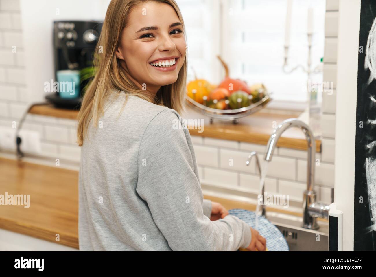 Caucasian woman washing dishes in kitchen Stock Photo - Alamy