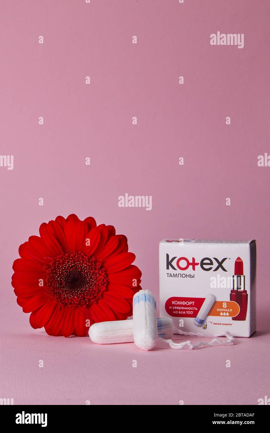 DNEPR, UKRAINE - MAY 20, 2020: menstrual sanitary cotton tampons, box of Kotex for tampons and red flower on pink background. Stock Photo