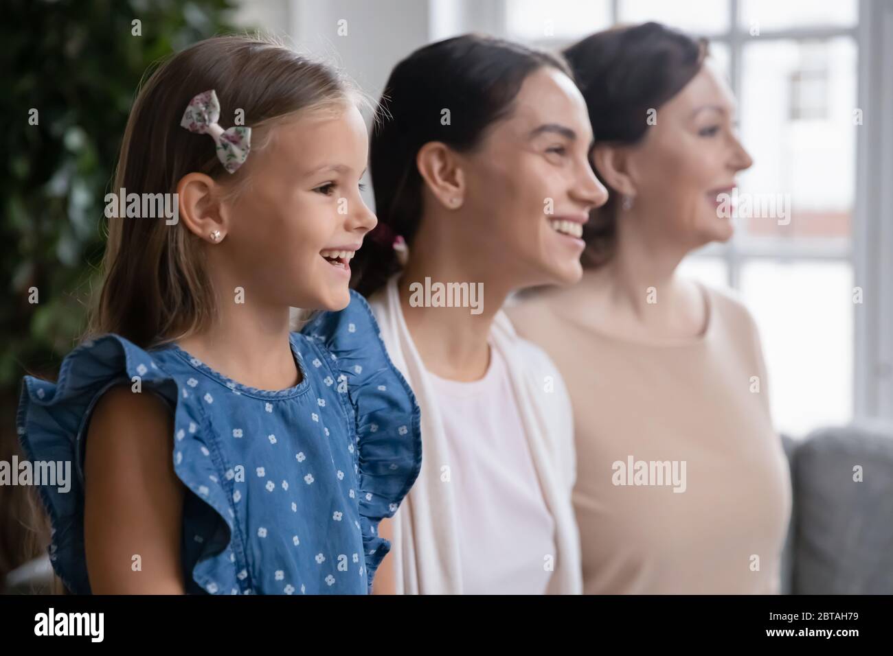 Profile view of happy three generations of women posing Stock Photo