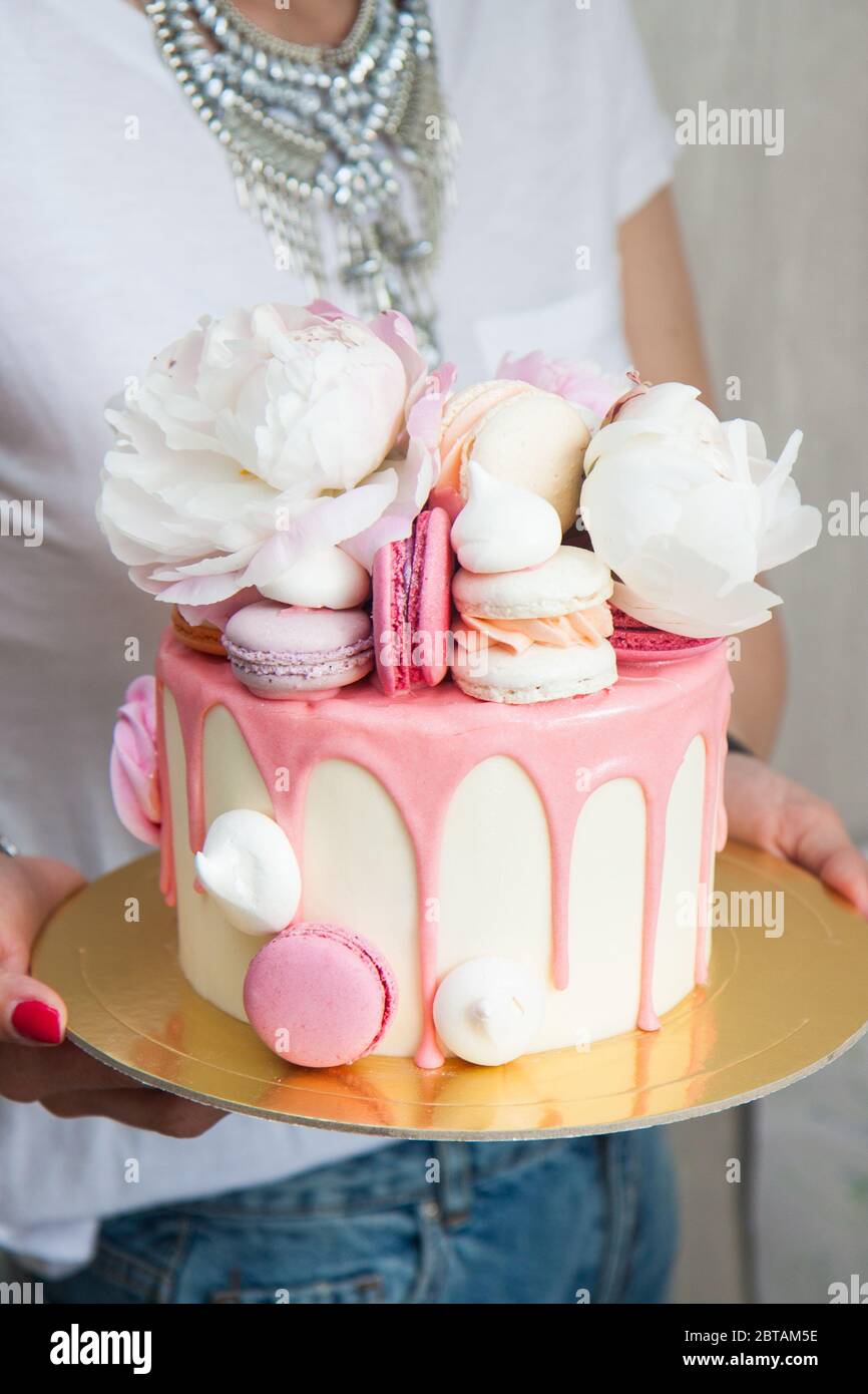Birthday cake decorated with melted pink chocolate, fresh peony ...