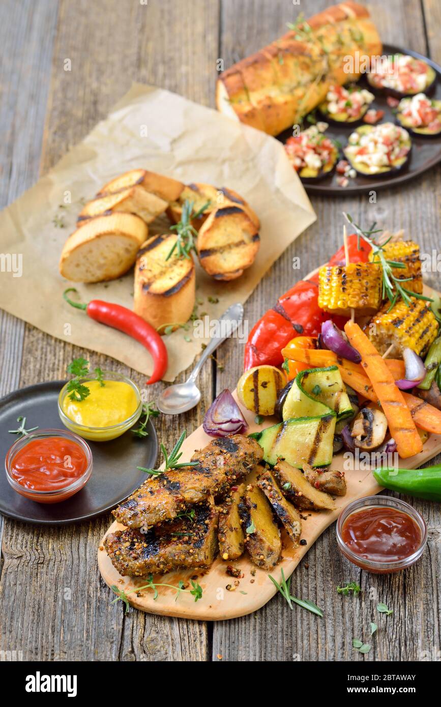 Grilled vegan seitan steaks with mixed vegetables, spicy sauces and