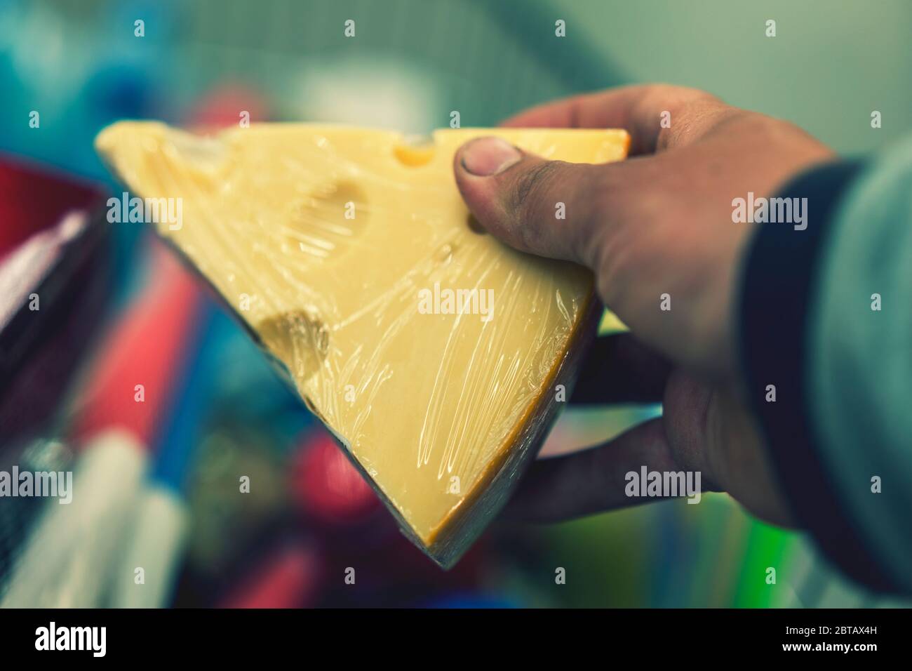 Male hand holds cheese in a supermarket. toned Stock Photo - Alamy