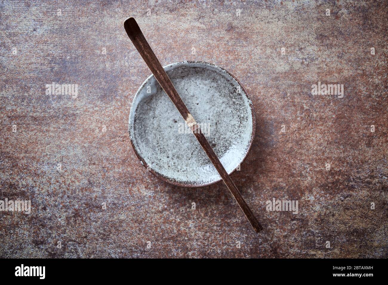 Chashaku Matcha spoon and empty ceramics plate on rustic stone background. Symbolic image. Asian culture. Top view. Copy space. Stock Photo