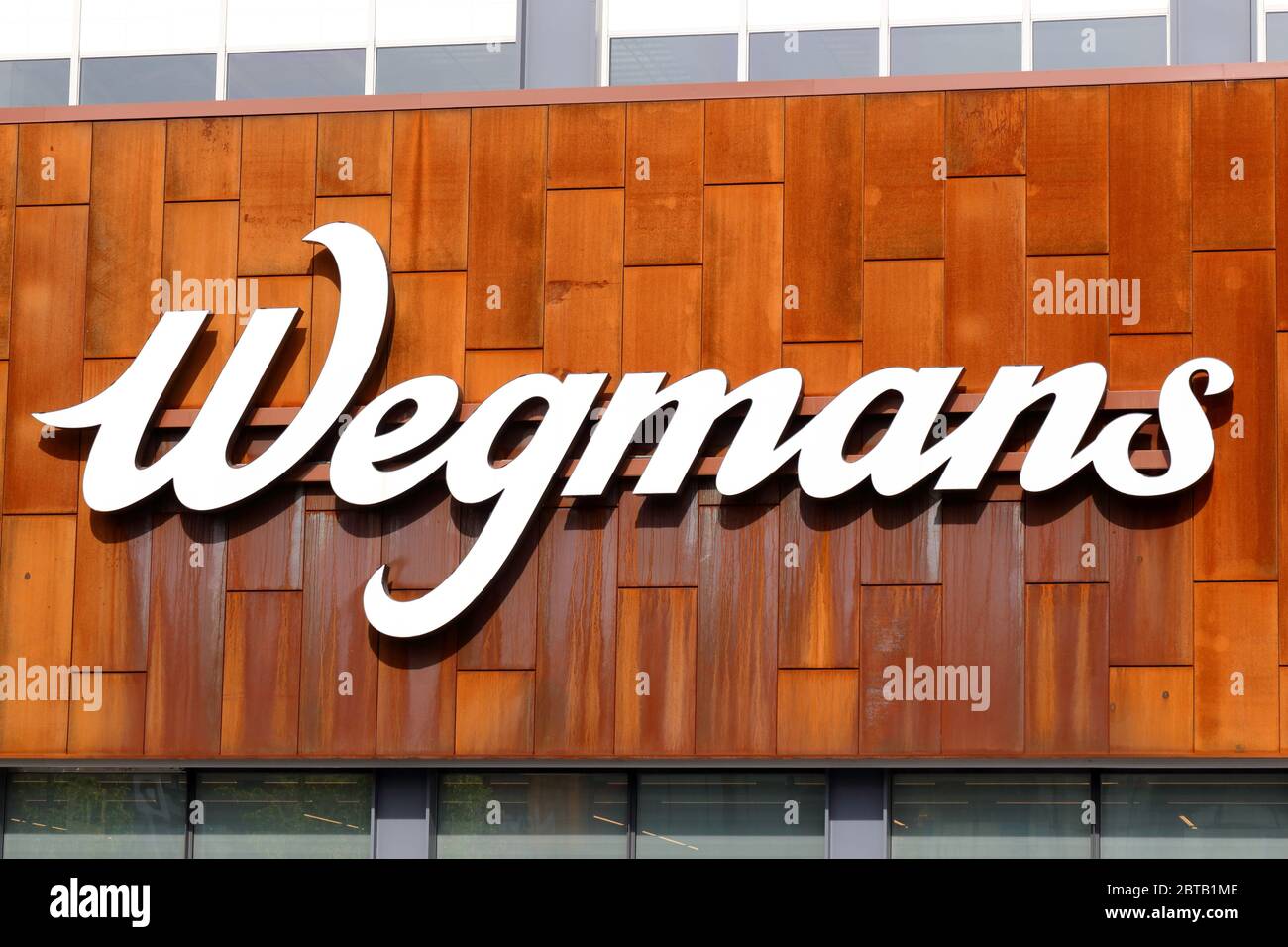 A large Wegmans logo against rusty metal at their supermarket in the Brooklyn Navy Yard Stock Photo