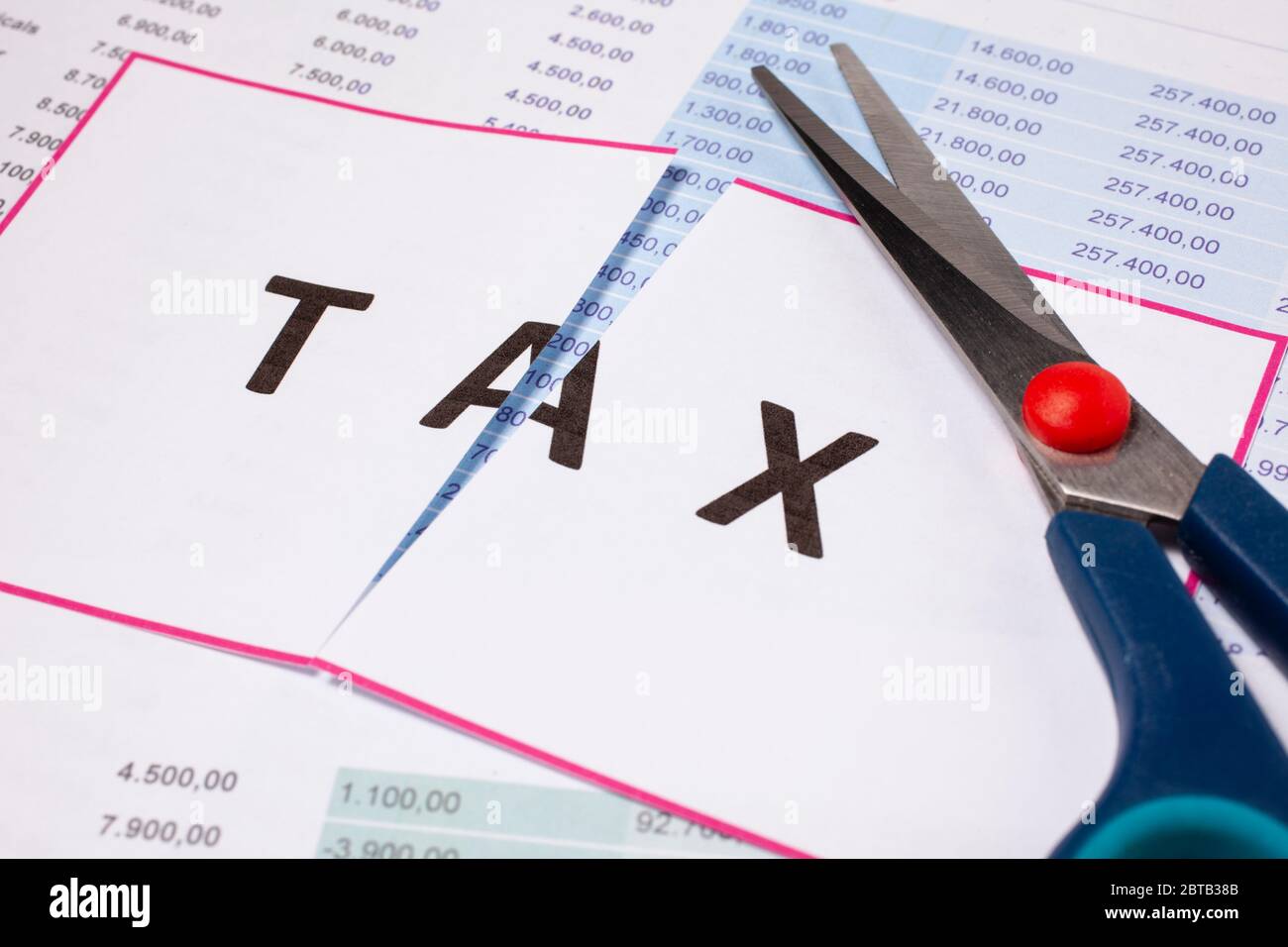 Cut taxes concept. Sciccors cut paper with word Tax Stock Photo