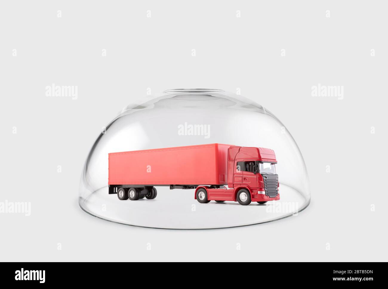 Red long truck with a trailer protected under a glass dome Stock Photo