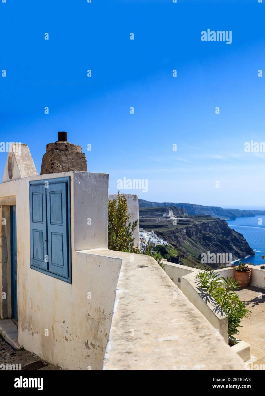 Santorini island, Greece. Traditional architecture, house entrance, terrace and caldera view over Aegean sea, blue clear sky, calm sea Stock Photo