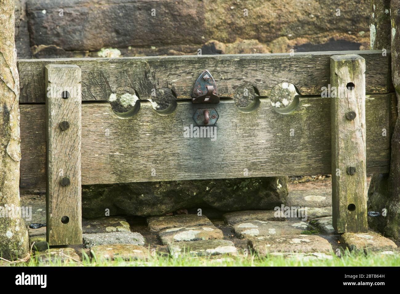 Old stocks and the stump of a cross on the village green at Bolton-by-Bowland in the Forest of Bowland, Lancashire Stock Photo