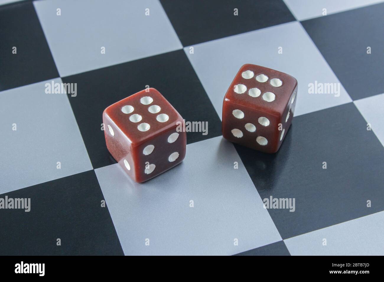 Playing dices with six numbers on chessboard surface Stock Photo