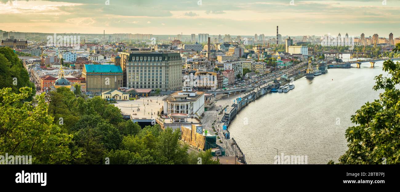 View to Podil District of Kyiv city at sunset from the Pedestrian Bridge. Stock Photo