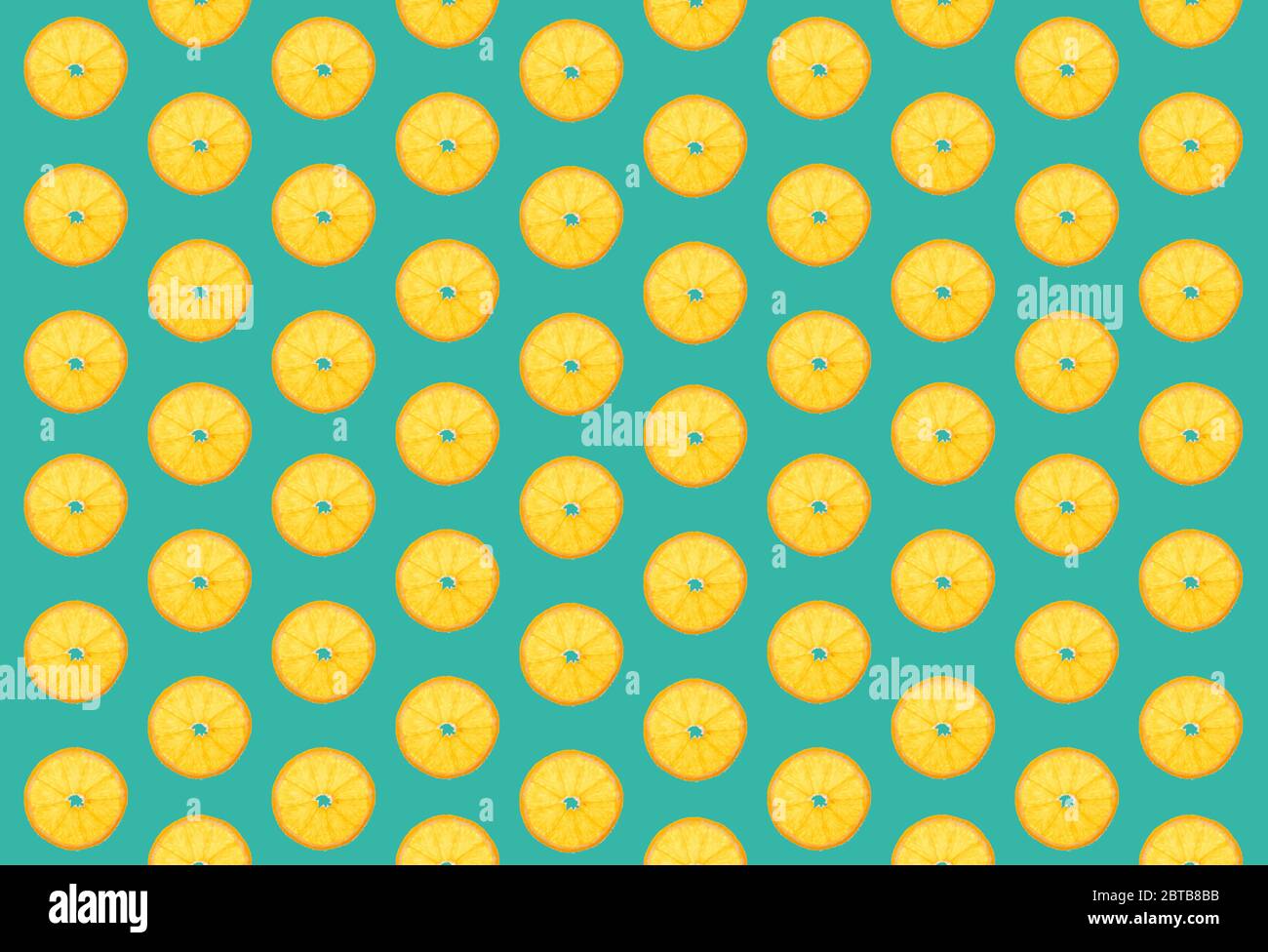orange slices in grouped order, turquoise background, wallpaper Stock Photo