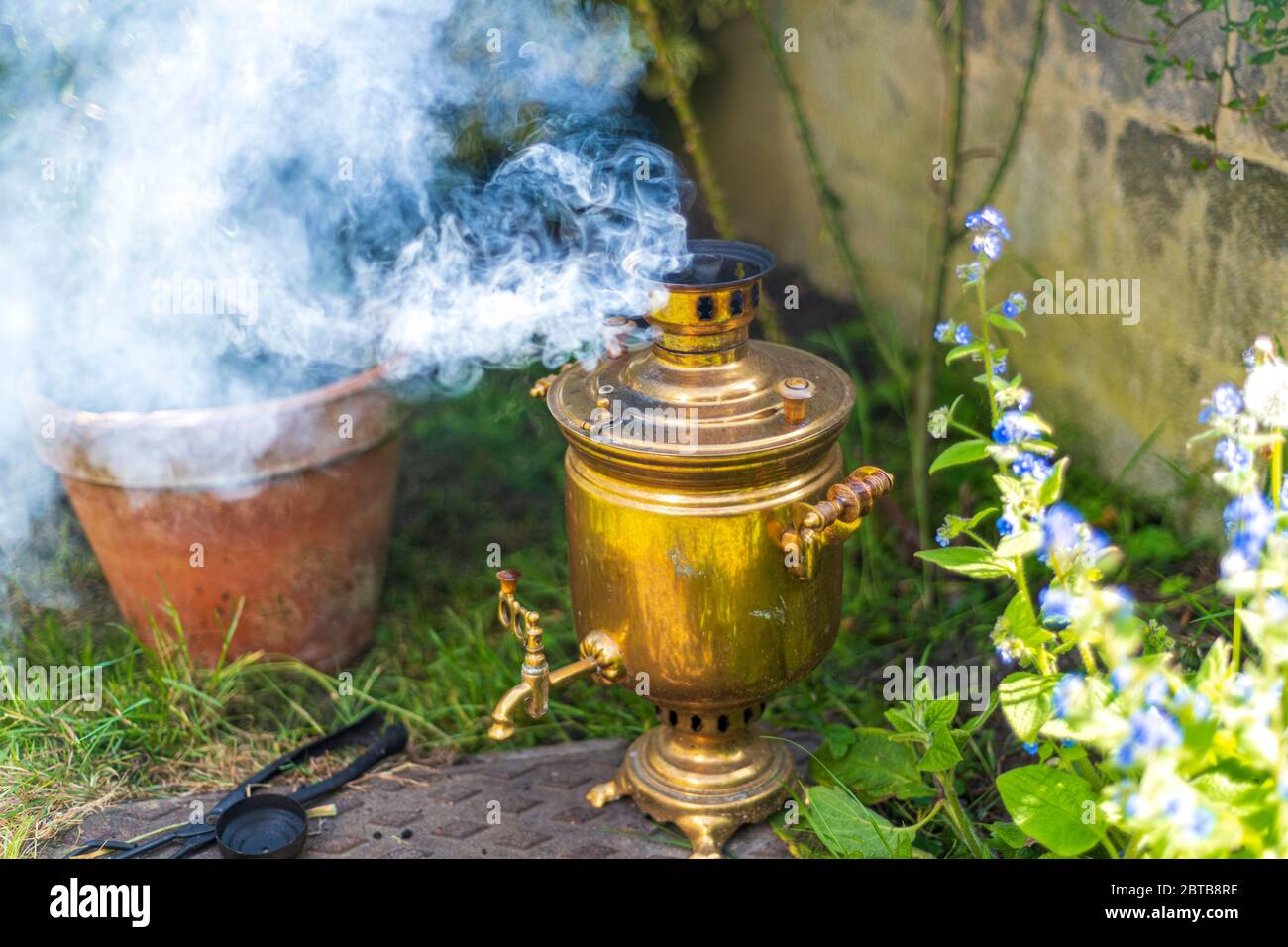 Old vintage samovar with smoke. Brewing tea in the old fashioned way. Russian ceremony Stock Photo