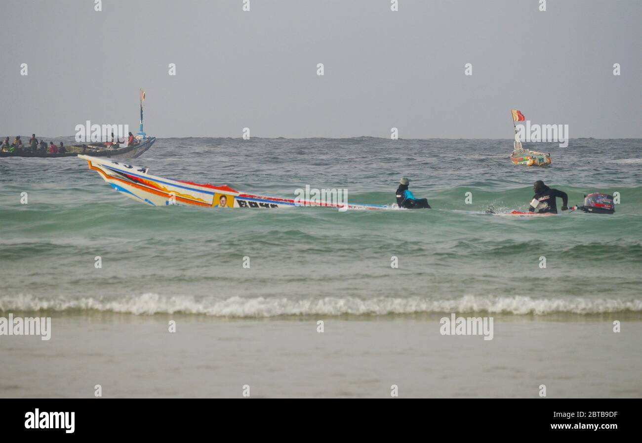 A pirogue (artisanal fishing boat) braving the surf at Yoff beach, Dakar, Senegal Stock Photo