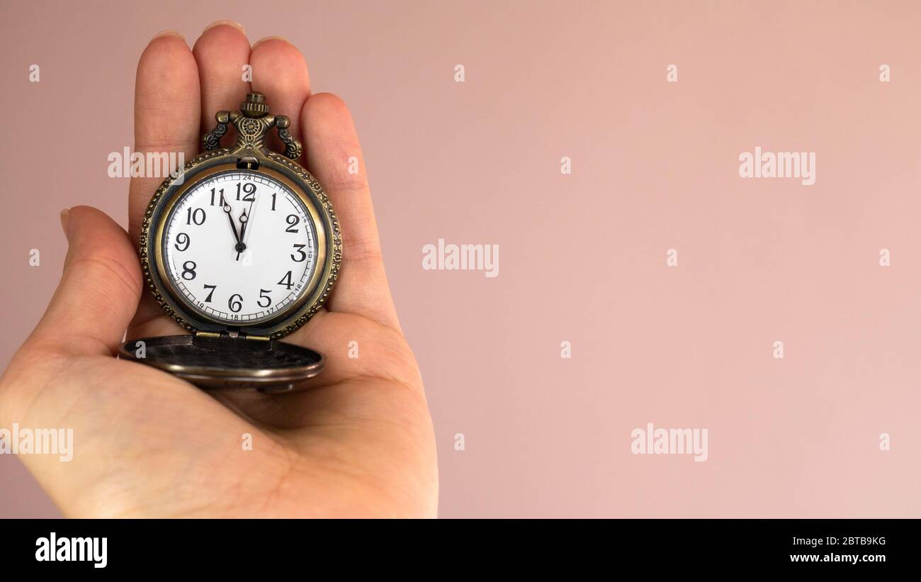 5 minutes to 12 o'clock. Pocket watch in hand. Negative space. Copy space for text Stock Photo