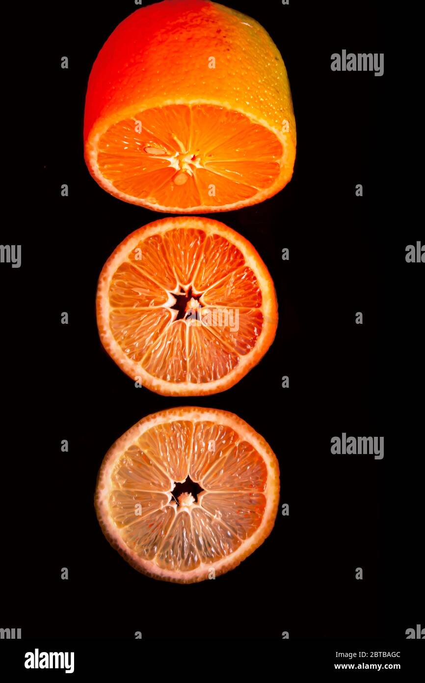Sliced orange isolated on black background. Fruit chips. Stock Photo