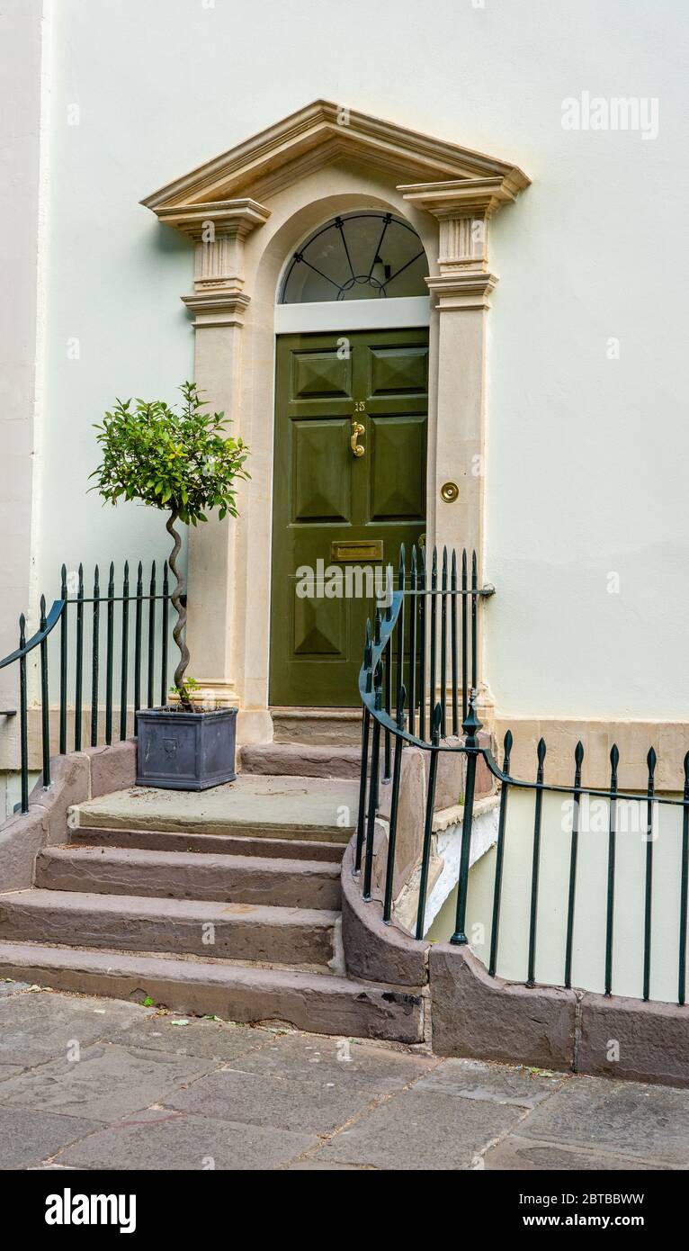 Elegant Georgian door with steps leading up to stone pediment and flanking columns on a street in Clifton village in Bristol UK Stock Photo