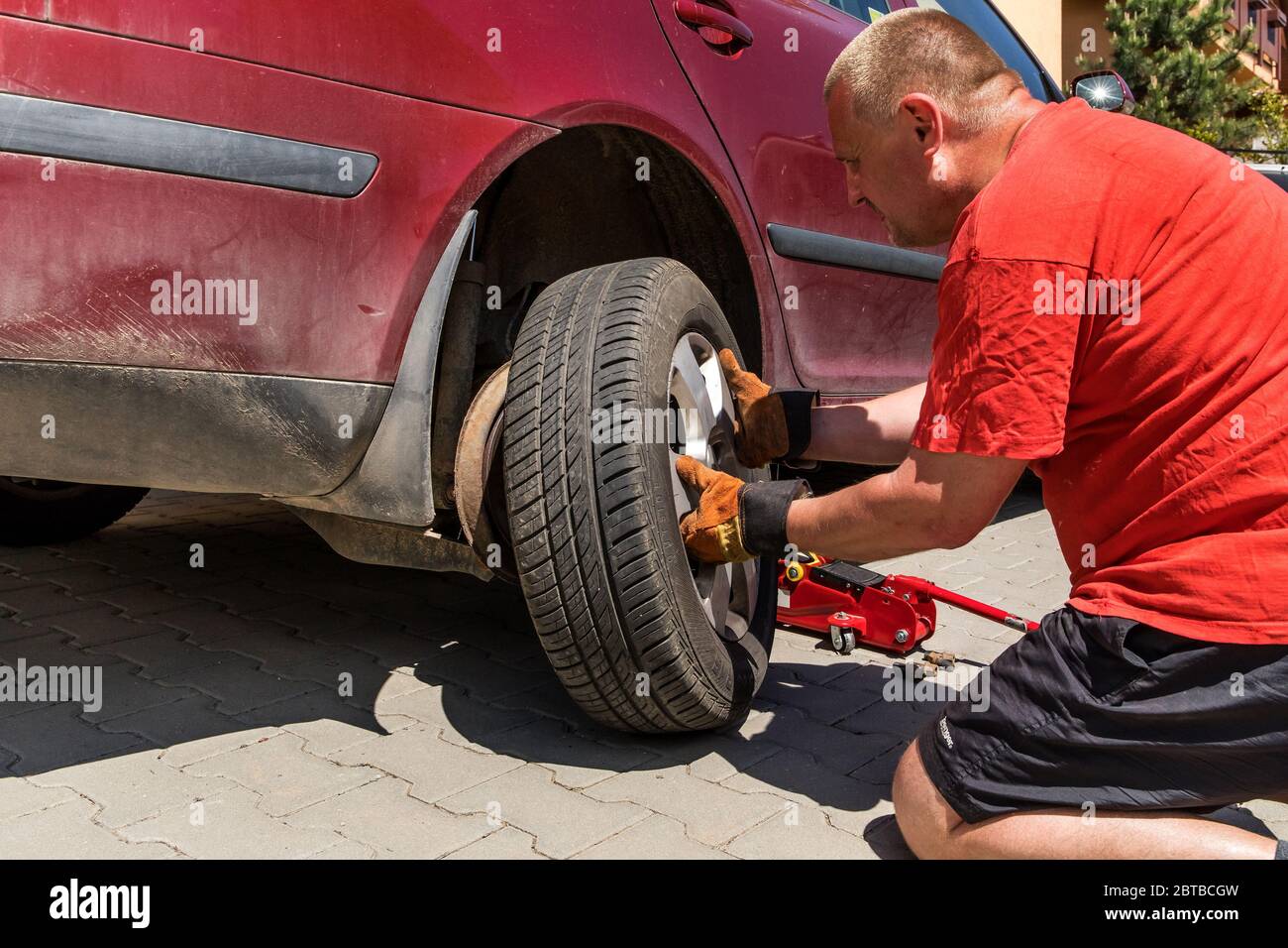 Man changing a wheel in his car. Damaged tire. Car repair on the road Stock Photo Alamy