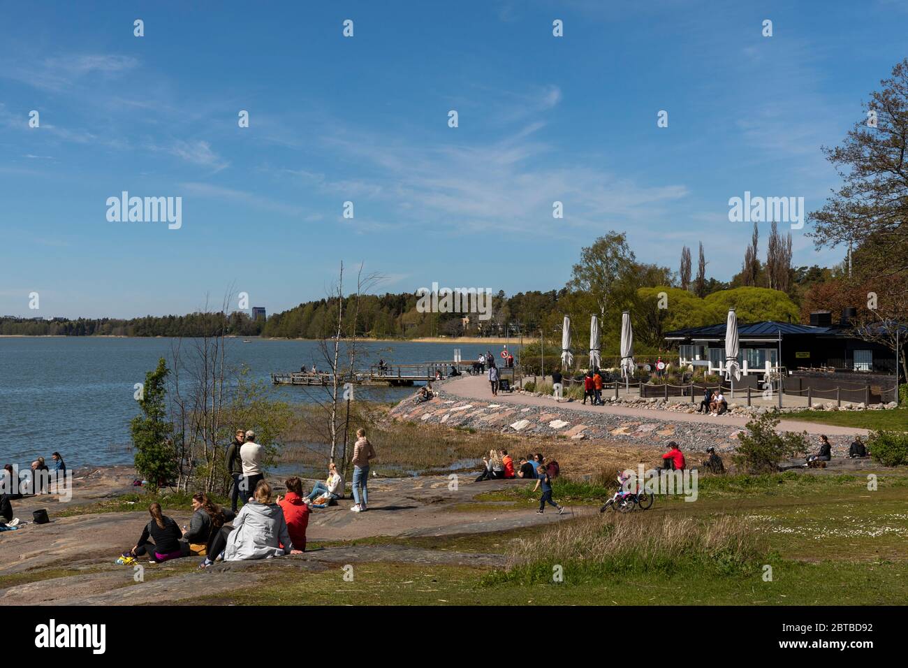 Warm spring days make people get outside and gather in public parks and beaches in Helsinki. Social distancing is being applied though. Stock Photo