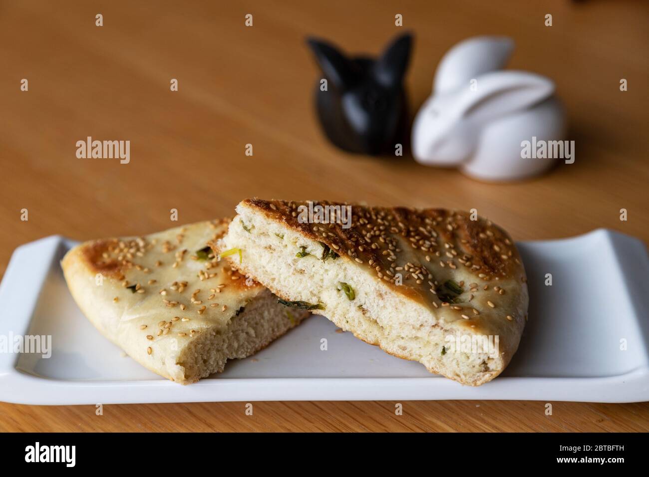 Close up of Chinese halal food known as sesame scallion bread, a popular staple in Northern China. The bread is stuffed with spring onions and topped Stock Photo