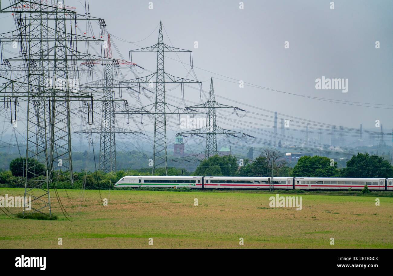 Train on the line between Essen and Bochum, power lines, extra-high voltage grid, 380 kilovolts, transports electricity generated in large power plant Stock Photo
