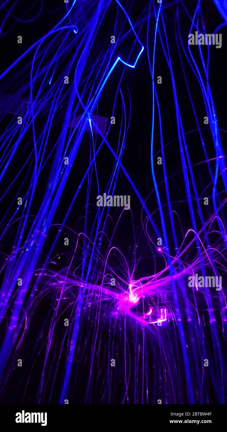 Overlaying wavy lines forming an abstract pattern on a dark background Stock Photo
