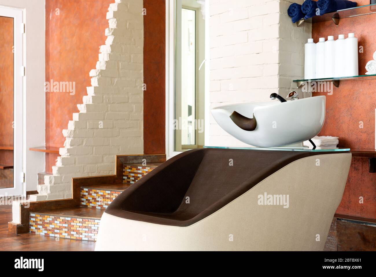 Beauty Salon Interior. Wash sink, Hairdressing bowl for washing hair, hair care spa procedures in Barber shop, shampoos, towels. Hairdresser stylist Stock Photo