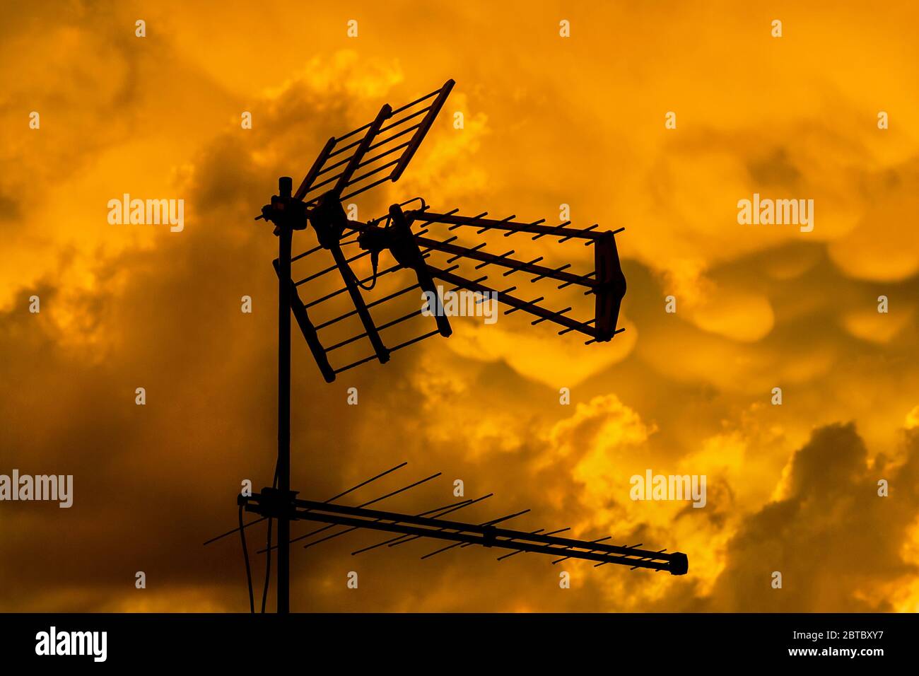 TV antennas and arrays with golden sunset sky and clouds Stock Photo