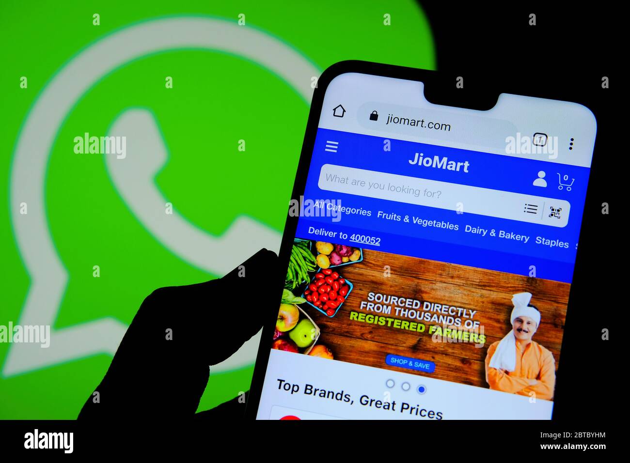 Stone / United Kingdom - May 24 2020: JioMart grocery shop seen on the smartphone screen and Whatsapp logo on a blurred background. The new service la Stock Photo