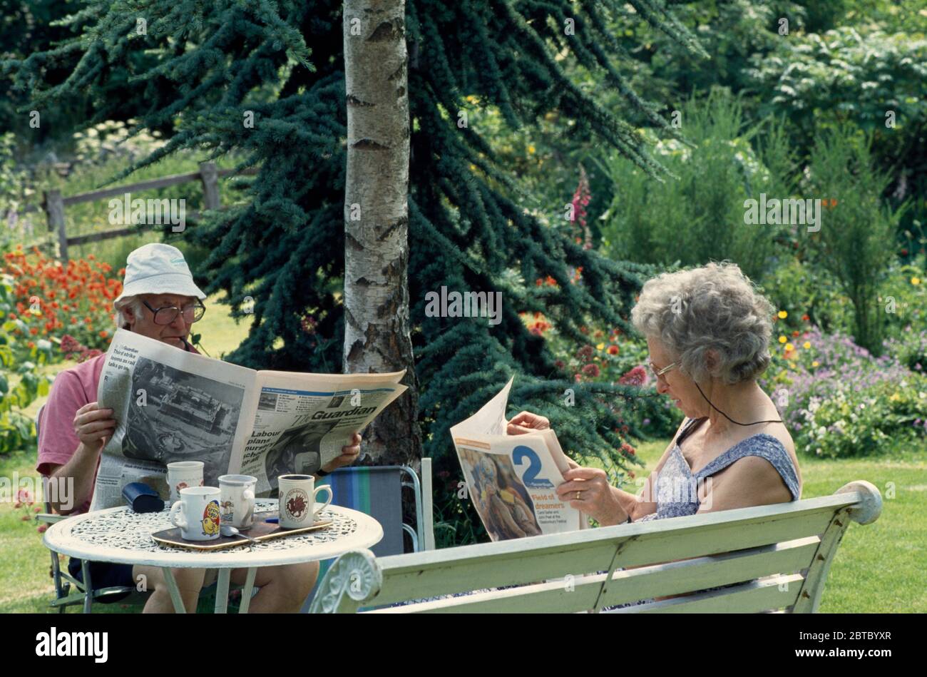 Older couple reading newspapers in the garden EDITORIAL USE ONLY Stock Photo Alamy