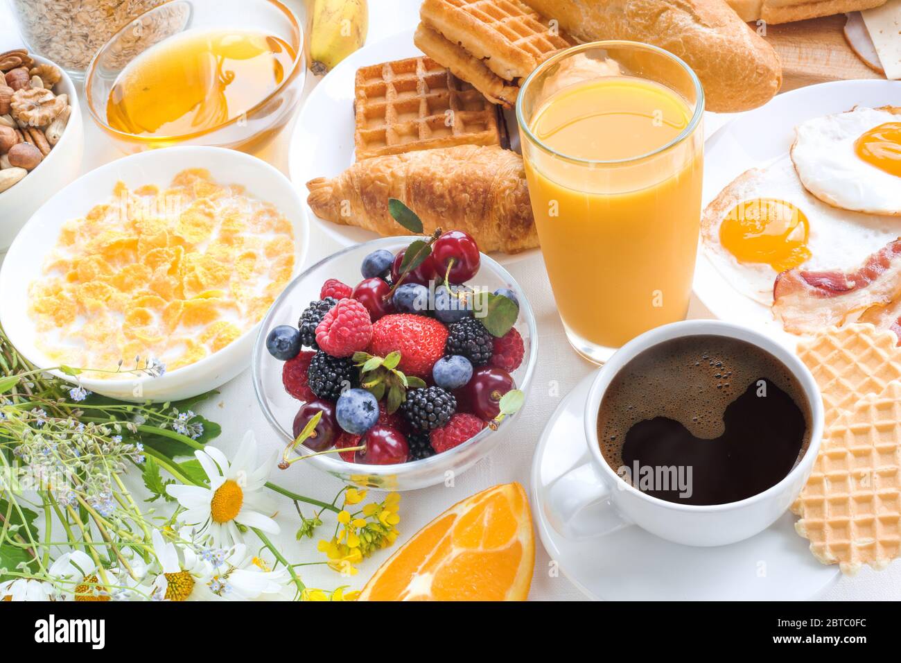 Healthy breakfast set with muesli, fruits, berries, nuts, coffee, eggs