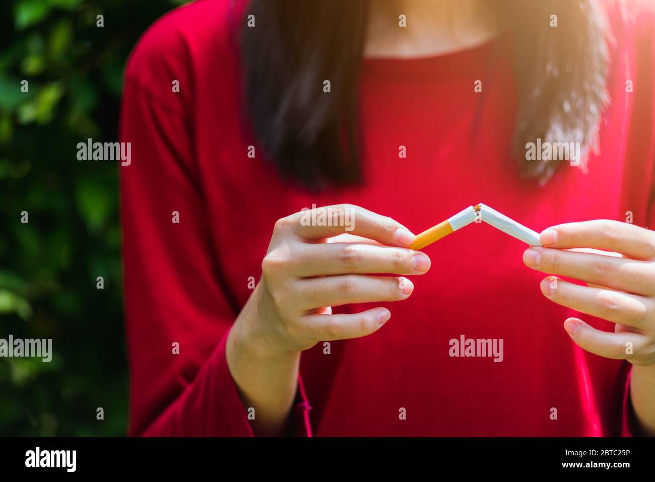 May 31 of World No Tobacco Day, Asian smoker woman use hands breaking down cigarettes, Stop or quit smoking concept Stock Photo