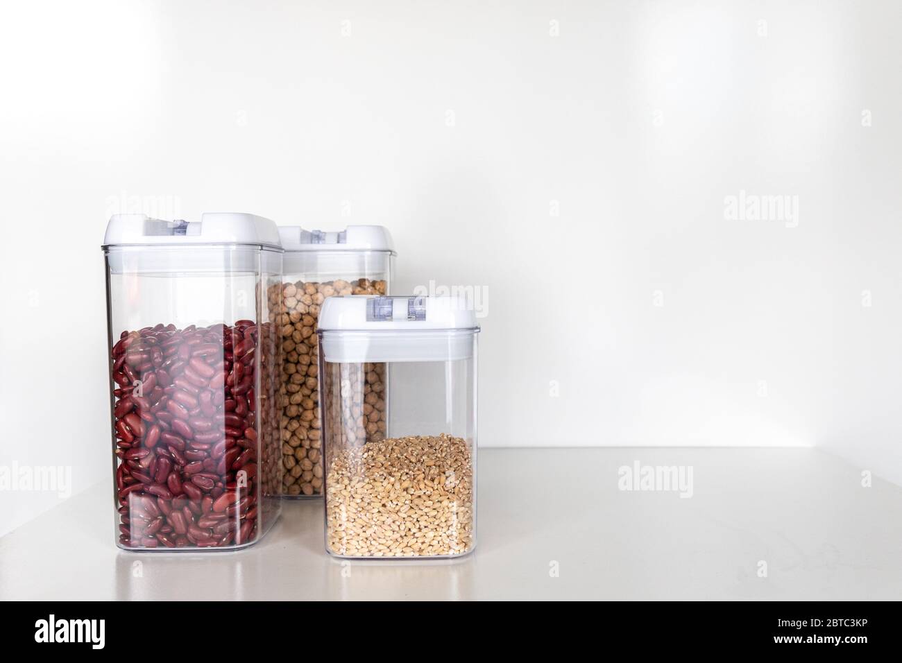 Three Clear Pantry Containers Filled with Non-Perishable Foods-- Dried Beans and Grains Stock Photo