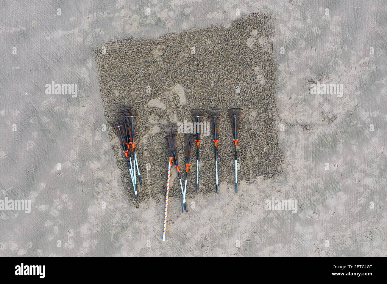 rakes in a box drawn in the sand using one of the rakes to crate ...