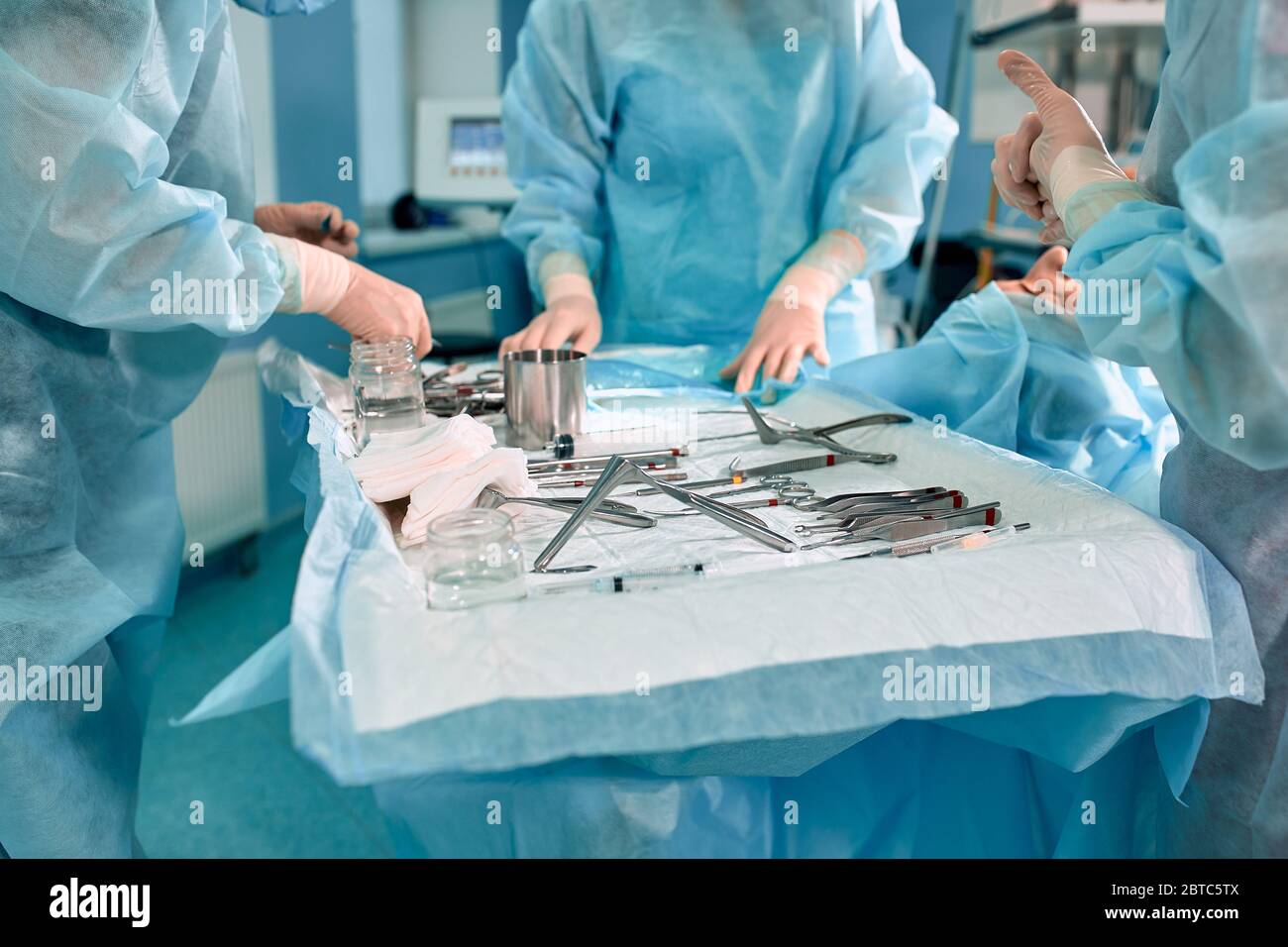 Sterile instruments on the operating table, a team of doctors lays out the  instruments for the operation. many hands are brewing in sterile gloves  Stock Photo - Alamy