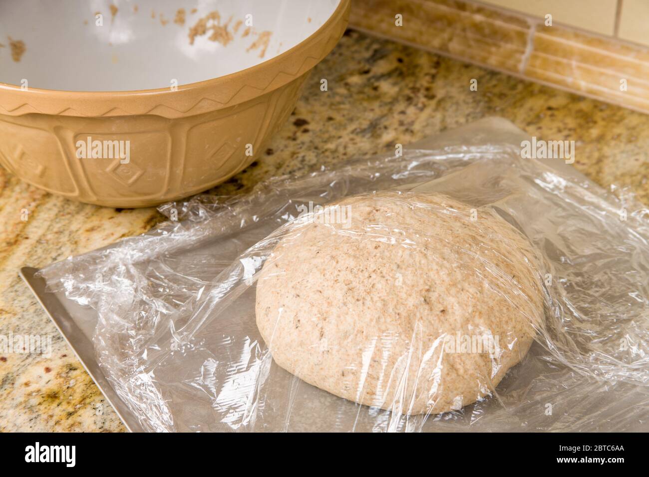 Bread may rise on the countertop if the temperature is 80 - 95 degrees Farenheit, as that is the ideal rising range to achieve the best structure, tex Stock Photo