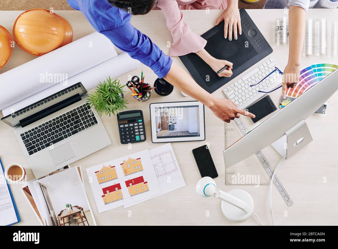 Group of interior designers critisizing work of colleague, pointing at ...