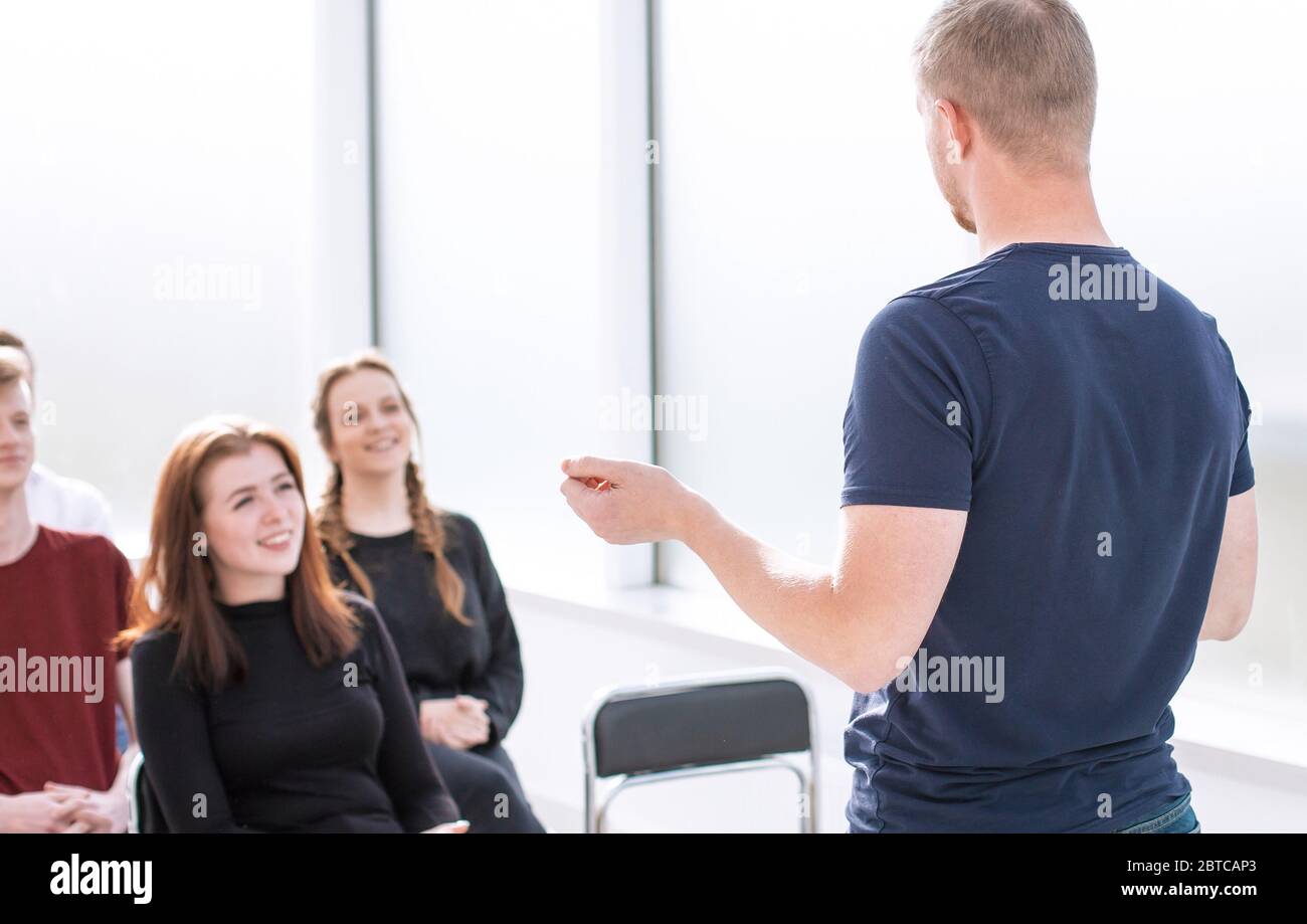 speaker makes a report for a group of diverse young people. Stock Photo