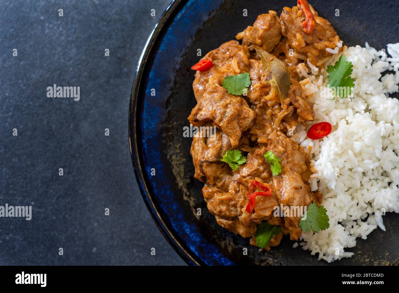 Chicken Tikka Masala curry served with rice on dark background, flat lay with copy space Stock Photo