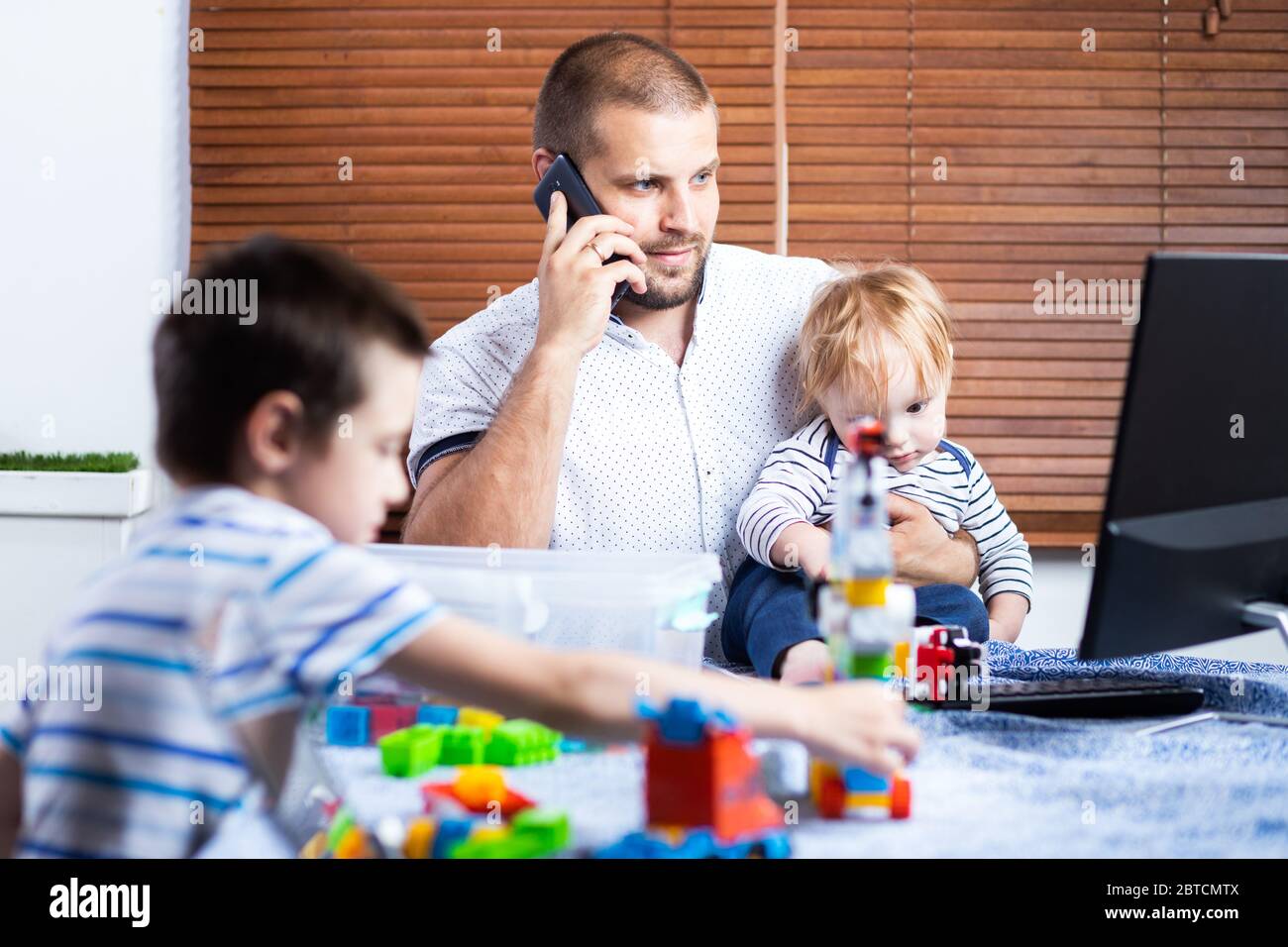 Young father business man parent interrupts by her kids sons while ...