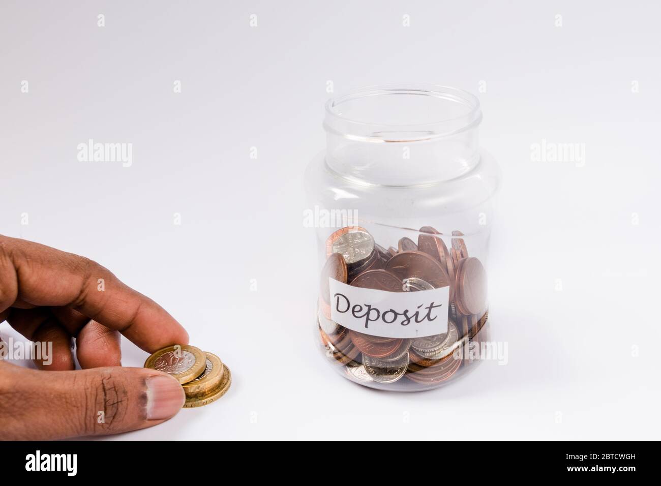 Money being added or removed from a Deposit jar saving pennies Stock Photo