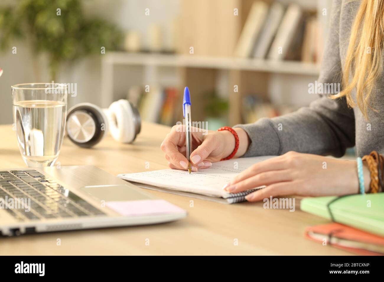 Close up of student girl hands writing on notebook doing homework stting on a desk Stock Photo