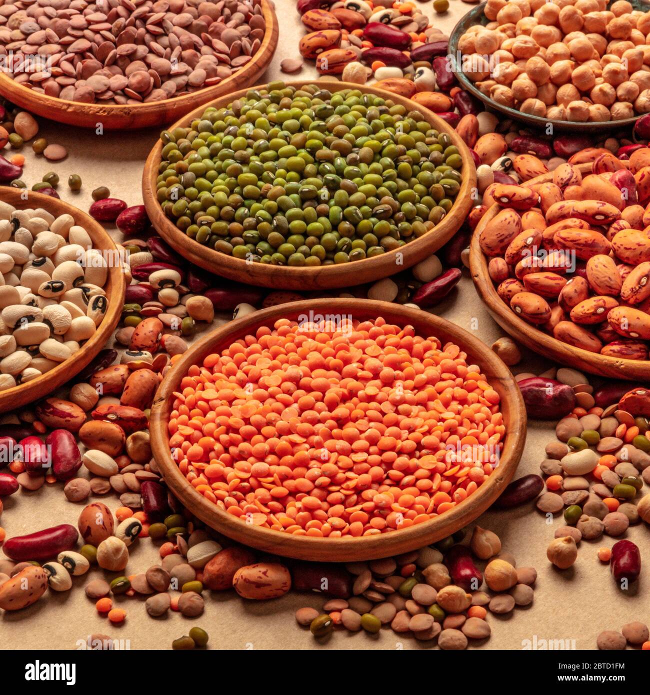 Legumes assortment on a brown background. Lentils, soybeans, chickpeas, red kidney beans, a
